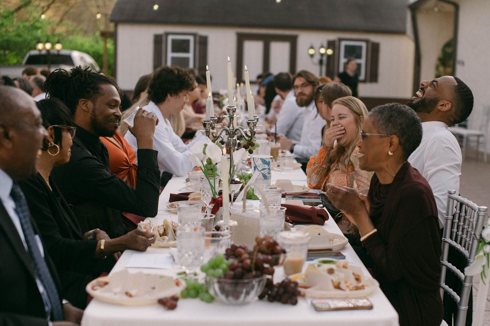 Wedding guests laughing at a candlelit reception table