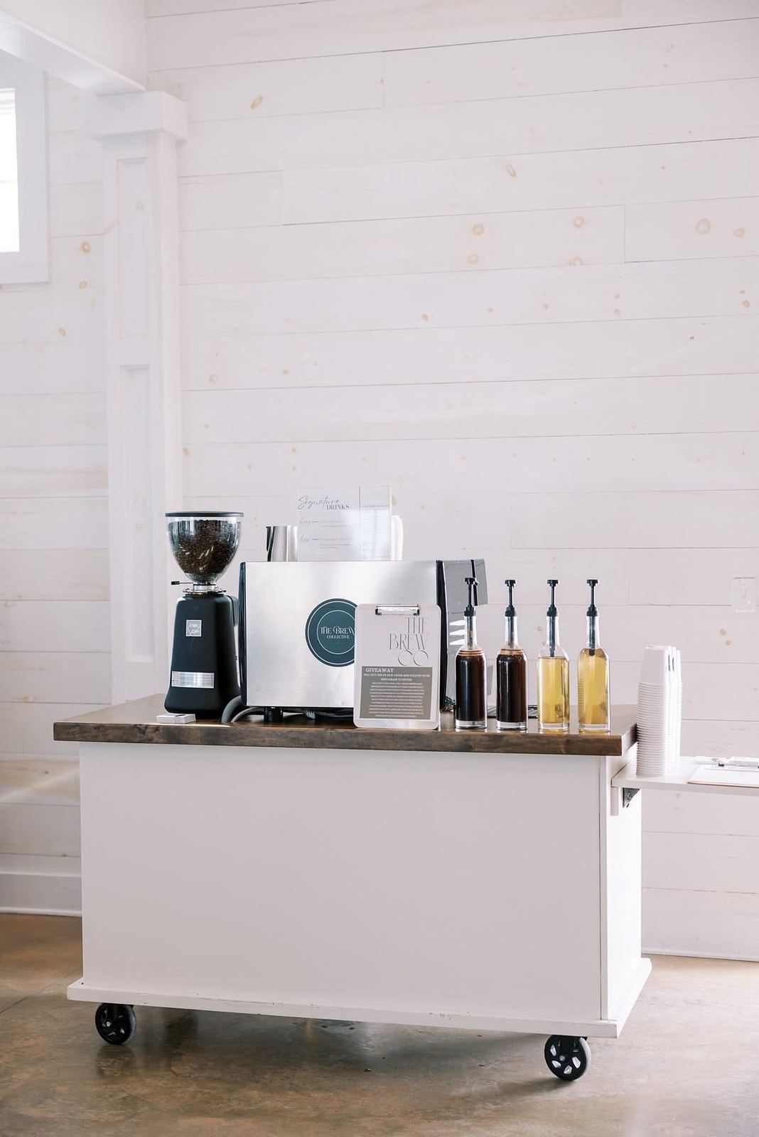 Styled espresso cart with signature drink menu in a white venue