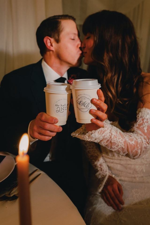 Newlyweds toasting with custom-labeled coffee cups