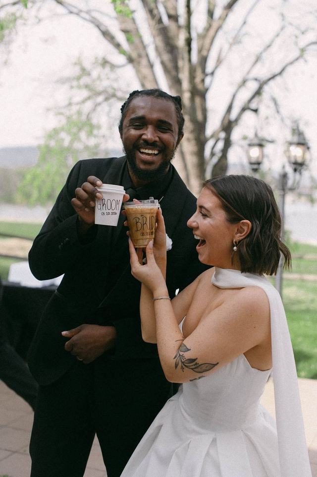 Bride and groom laughing with labeled coffee cups